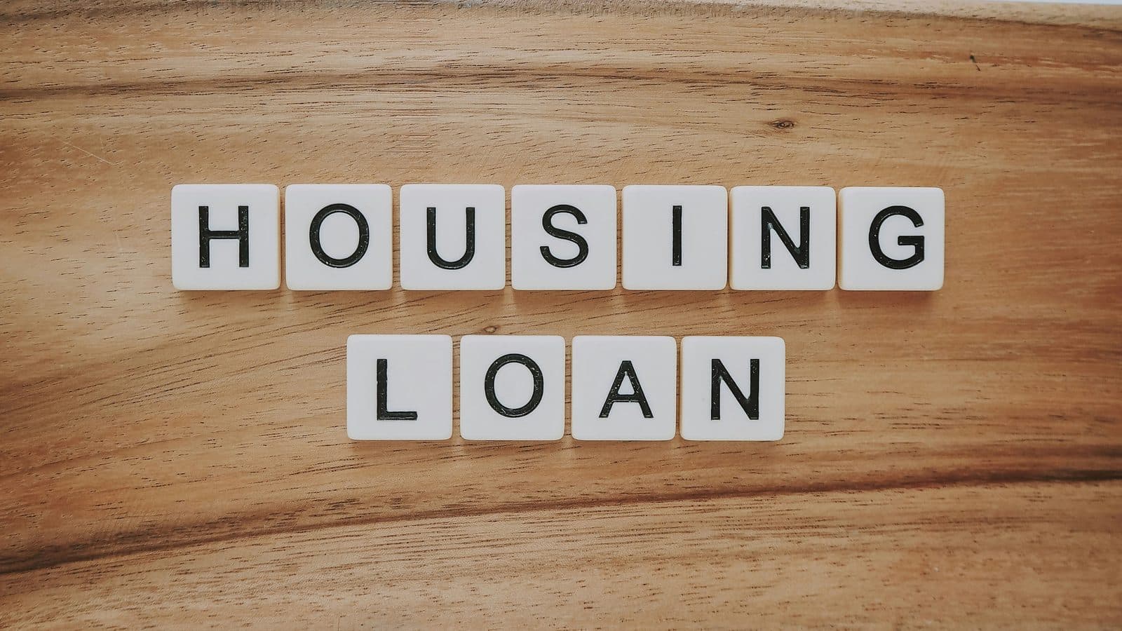 Letter tiles spelling housing loan on a desk